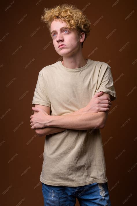 Premium Photo | Skinny young man with curly hair on brown