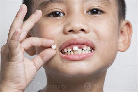 close up face baby Asian hold showing open mouth temporary lost tooth