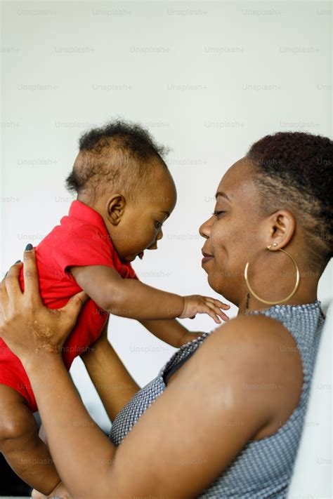 Foto Una mujer sosteniendo a un bebé en sus brazos – Familia Imagen en