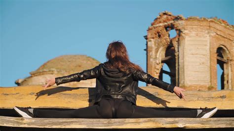 Beautiful athletic girl with a tough stretch is sitting in the splits