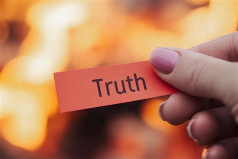 premium photo paper  inscription truth  womans hand  fire