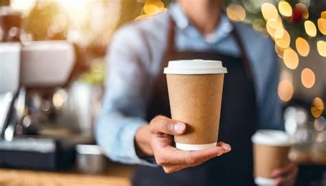 Baristas hand offers coffee in paper cup against cozy caf backdrop ...