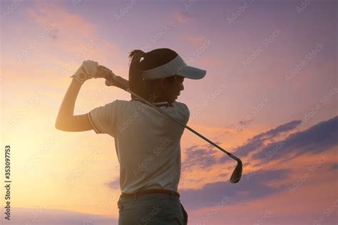 Young Women Asia player golf swing shot on course with sunset sky twilight background. exercise ...