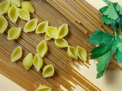 Spaghetti of two types on the table. shells and buckwheat pasta ...