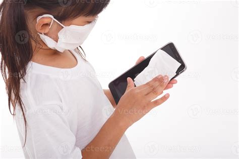 Asian girl wear mask cleaning smartphone screen with alcohol.on white