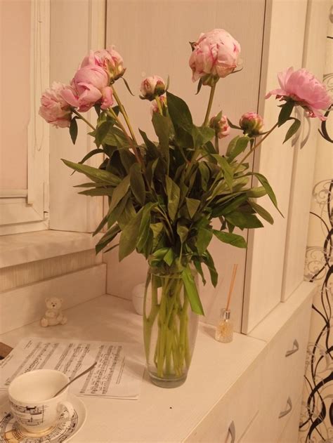 a vase filled with pink flowers sitting on top of a white dresser next ...