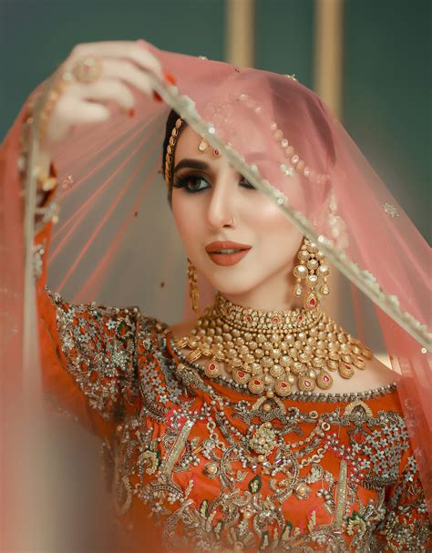 Una mujer con un traje de novia rojo y dorado foto – Imagen de Naeem Ad