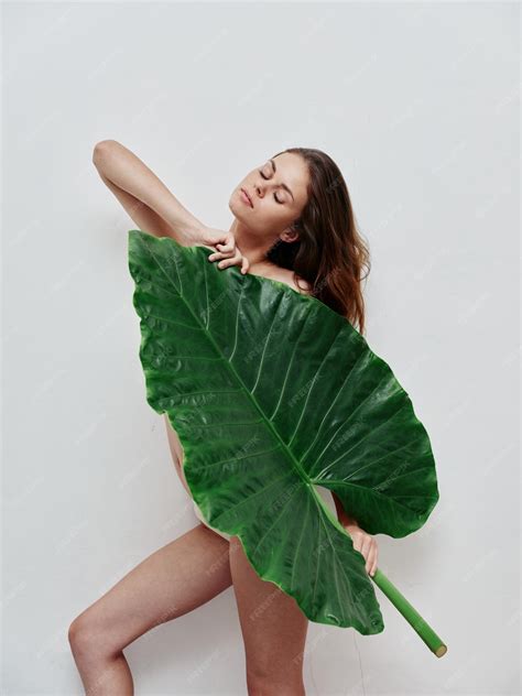 premium photo attractive woman covers naked body  green leaf