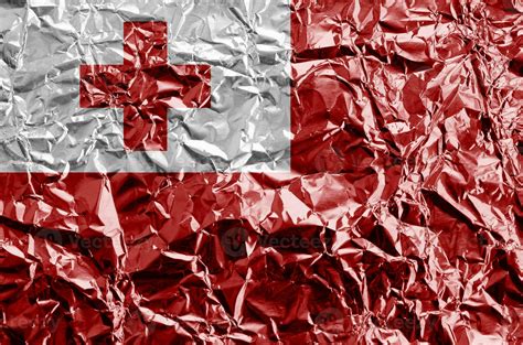 Tonga flag depicted in paint colors on shiny crumpled aluminium foil ...