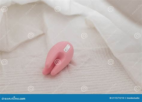 close    clitoral vibrator   white sheet   bed stock photo