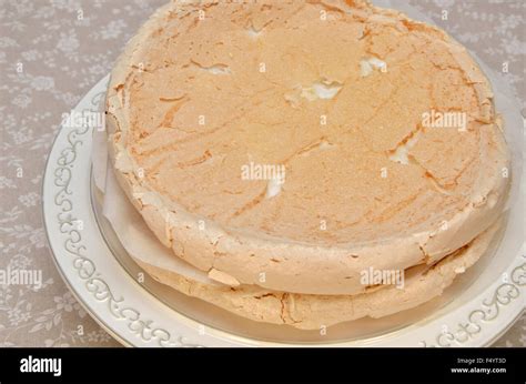 Crispy, fluffy merinque layers for beze cake on white cake plate Stock ...