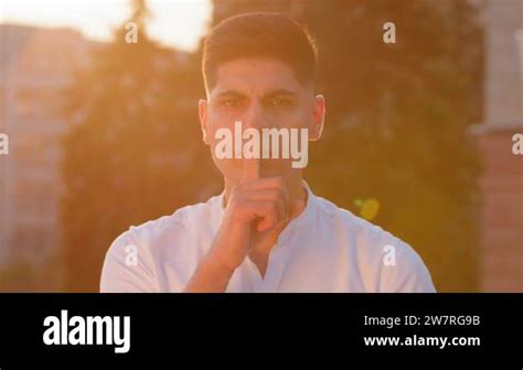 Young man eastern businessman hold finger on lips look at camera makes ...