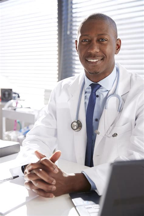 Portrait Of Smiling Male Doctor Wearing White Coat With Stethoscope ...