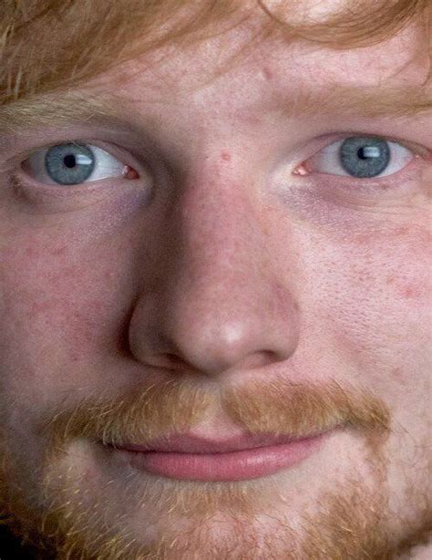 a close up of a man with blue eyes and red hair looking at the camera