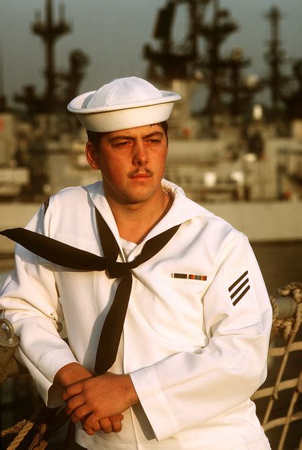 A sailor contemplates life at sea while leaning on the rail of his ship ...