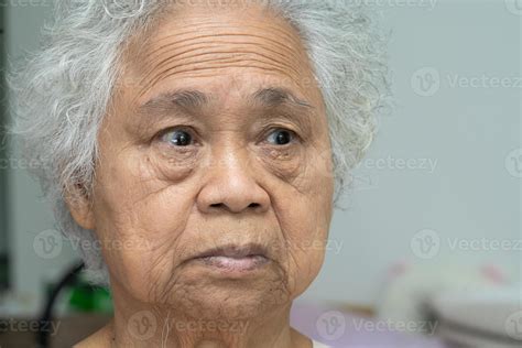 Asian elderly old woman face and eye with wrinkles, portrait closeup