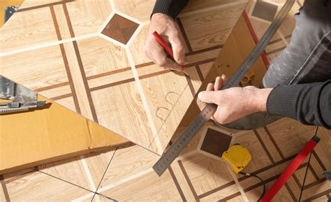 Premium Photo | Worker marking ceramic tile with pencil
