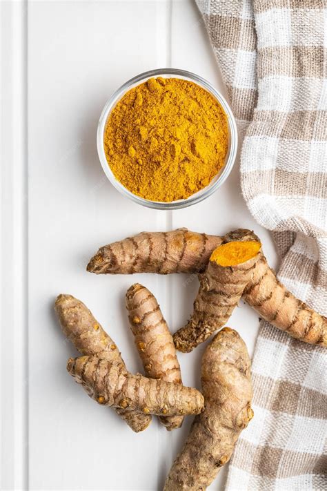 Indian turmeric powder and root turmeric spice ground turmeric in bowl
