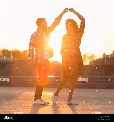 Love is in the air. Romantic couple dancing at sunset Stock Photo - Alamy