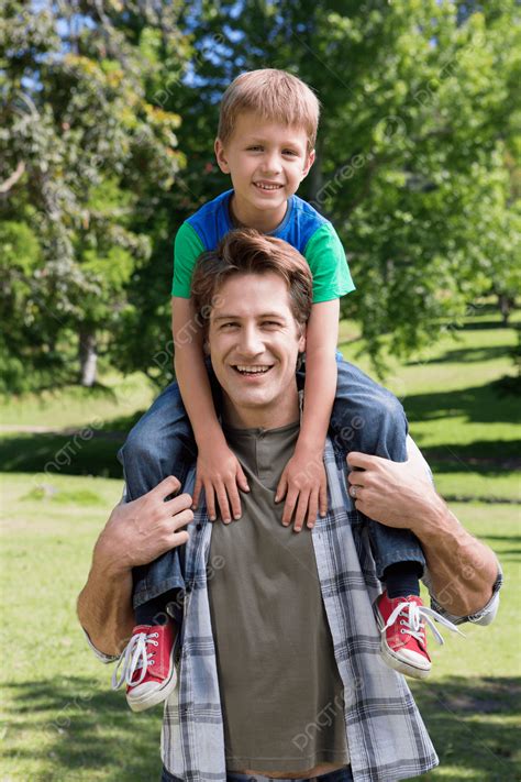 Dad And Son Enjoying Playful Moments In The Park Photo Background And