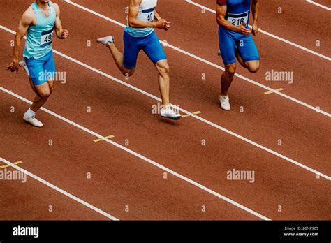 group male runners run  track stadium  track  field competition