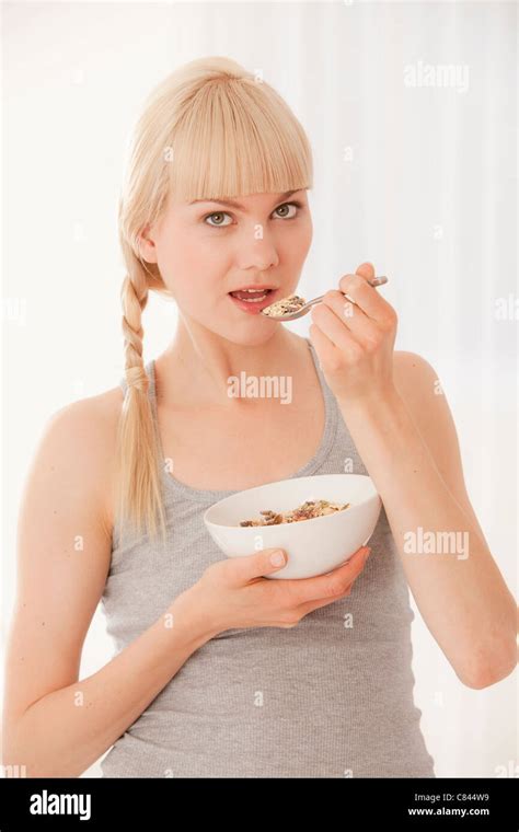 Woman eating bowl of cereal Stock Photo - Alamy