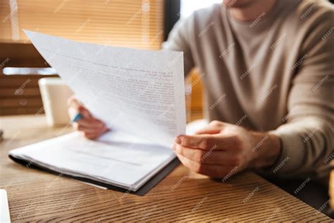 Подрезанное фото привлекательного молодого человека в работе офиса ...