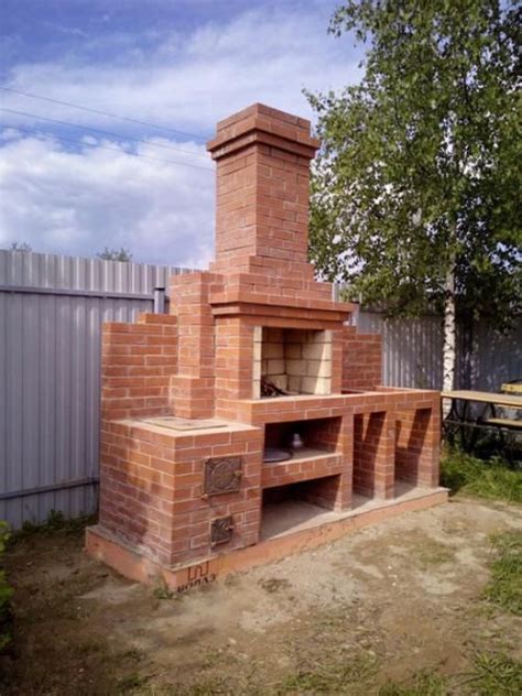 an outdoor brick pizza oven sitting in the middle of a yard