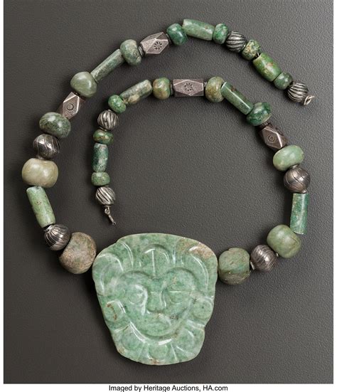 A NECKLACE COMPOSED OF A MAYA JADE PENDANT AND BEADS. c. 600 - 900
