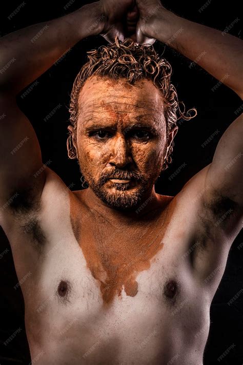 Premium Photo | Naked man with his face covered in clay