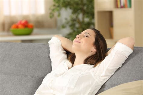 Woman relaxing alone on a couch at home - Jeanine Hofs