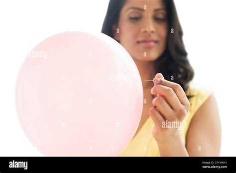 Woman popping pink balloon. Conceptual image for bloated stomach Stock Photo - Alamy