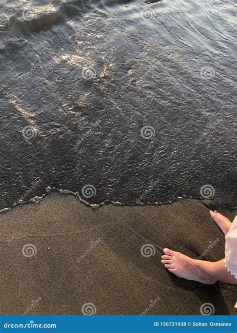 Giovane Ragazza Sulla Spiaggia. Cosce Nude E Onde Nere. Mar Nero