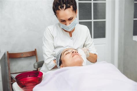 Um cosmetologista limpa a pele de um cliente de salão de beleza antes ...