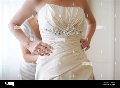 Putting beautiful wedding dress on Stock Photo - Alamy