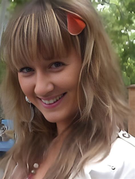 a woman with long blonde hair and cat ears on her head smiles at the camera