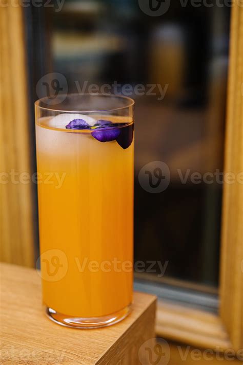 Refreshing orange cocktail with edible flower garnish 45605173 Stock
