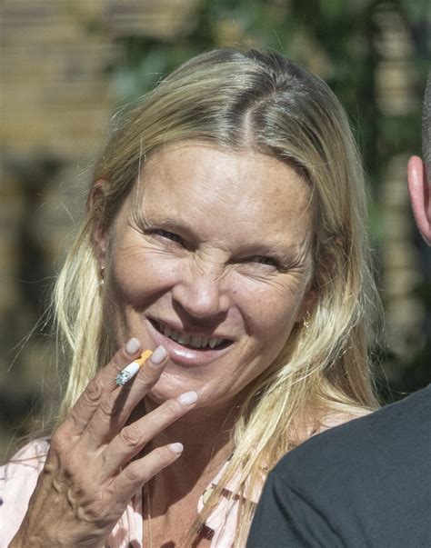 Kate Moss looks unrecognizable while smoking a cigarette during family