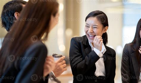 Asian business people talking and laughing in office building. Young
