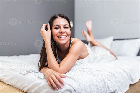 sensual sonriente joven mujer con largo pelo sentado y extensión en