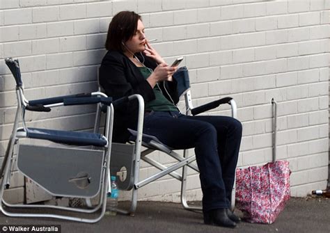 Elisabeth Moss cuts a sombre figure as she puffs on a cigarette while ...