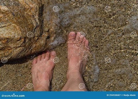 босоногие женщины-ножки закрываются в чистой воде на песчаном дне ...