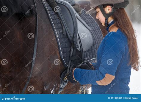 Young Girl Adjusting Stirrups before Riding Horse Stock Image - Image ...