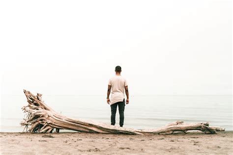 Back view Photo of Man Standing Beside Body of Water · Free Stock Photo