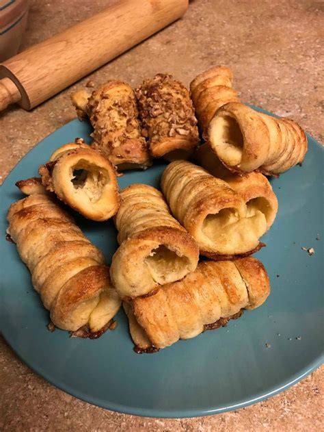 a blue plate topped with pastries on top of a counter next to a rolling pin