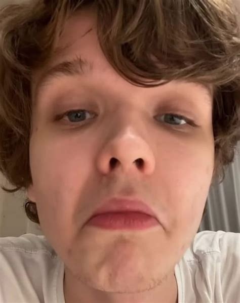 a close up of a person wearing a white t - shirt and looking at the camera