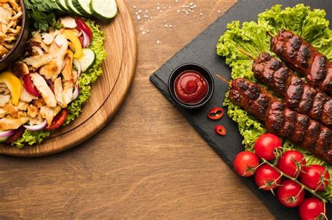 Вид сверху вкусного шашлыка на сланце с кетчупом и столовыми приборами ...