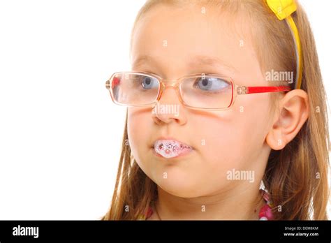 Funny little girl in glasses doing fun saliva bubbles studio shot