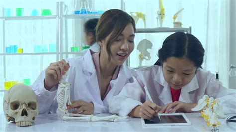 Asian schoolgirls are studying science and technology in a lab