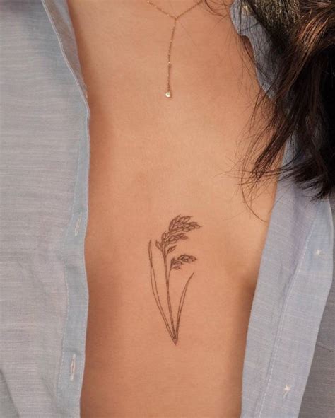 Fine line rice plant tattoo on the sternum.